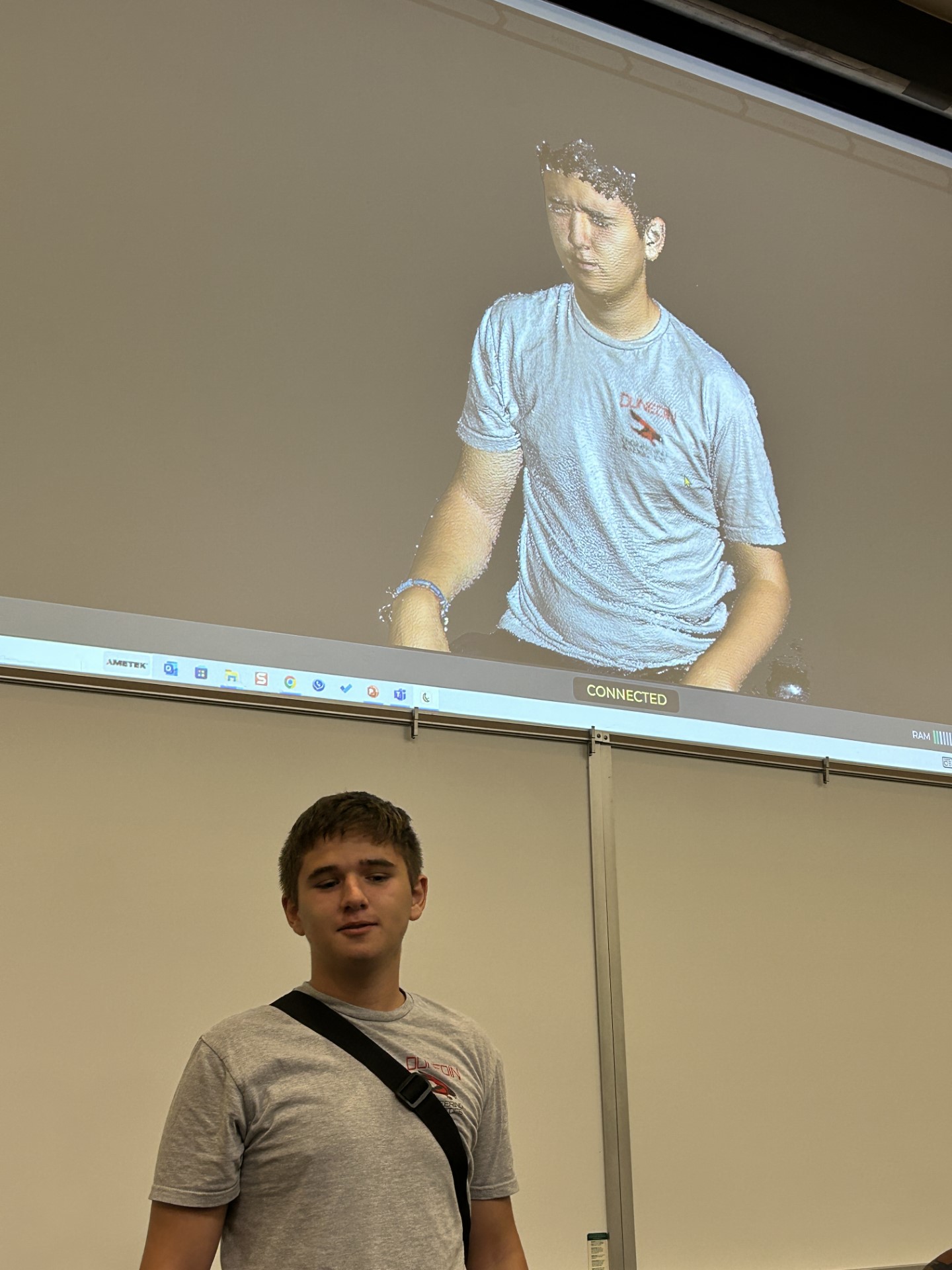 A person standing in front of a projector screenDescription automatically generated